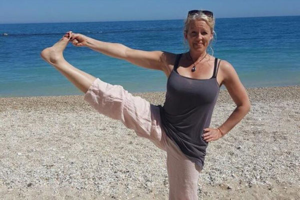Janne in yogahouding op strand